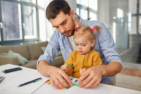多任务处理，自由职业者和父亲的概念—工作的父亲与婴儿女儿在家庭办公室。工作父亲与婴儿女儿在家庭办公室