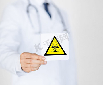 健康、医学和流行病概念—男医生举着警告火灾标志。男医生举着火灾警告牌