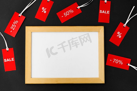 购物和出口概念—白板和红色标签与折扣标志在黑色背景。白板和带有折扣标志的红色标签