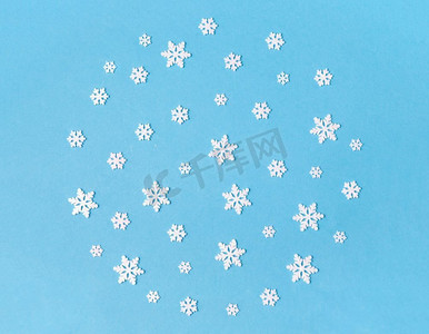 白色雪花摄影照片_圣诞节，雪和冬季假期概念—白色雪花装饰在蓝色背景。白色雪花装饰在蓝色背景