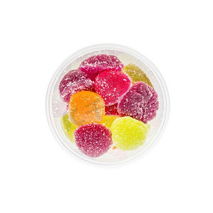 泡沫装水果摄影照片_五颜六色的果冻装在敞开的泡沫瓶里，白色背景。俯视图。