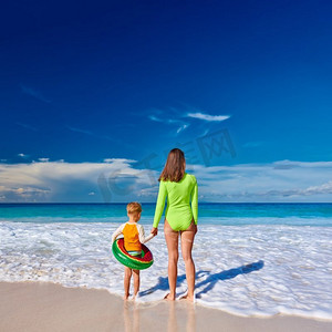 三岁的小男孩和妈妈一起在海滩上。夏季家庭度假在塞舌尔，马埃岛。