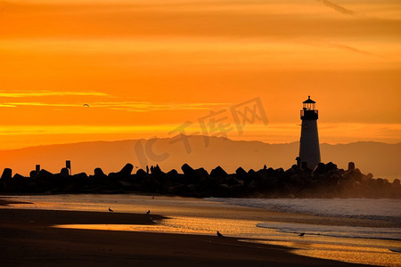 剪影灯塔摄影照片_圣克鲁斯防波堤灯（沃尔顿灯塔）在日出，太平洋海岸，加利福尼亚州，美国