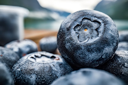 木桌上放着蓝莓抗氧化剂，背景是挪威的大自然。
