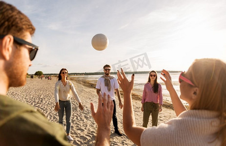 排球，休闲游戏和人的概念—快乐的朋友在沙滩上玩球在夏天。夏天在沙滩上打排球的朋友