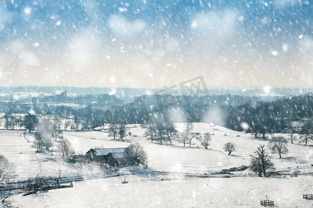 乡村景观横跨乡村环境，地面上有冬天的雪，大雪中有明亮的蓝天背景