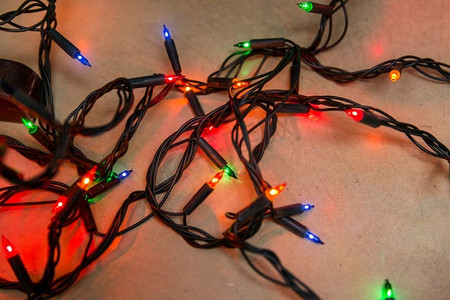 圣诞节，假日和照明概念—电花环灯在木背景。圣诞节花环灯在木背景