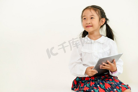 小孩子摄影照片_白色背景，平板电脑，快乐的小孩子。童年的生活方式..白色背景的小孩拿着平板电脑。