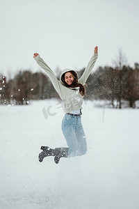 快乐的女人跳跃户外冬天