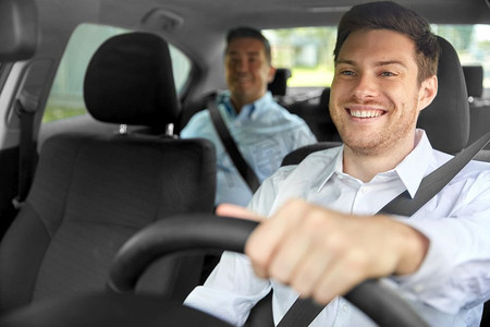 运输、车辆和出租车概念—快乐的微笑男性司机驾驶汽车与乘客。男出租车司机驾驶汽车与乘客