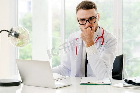 医生在办公桌上工作在膝上型计算机在医院。医疗保健概念医生在笔记本电脑医院工作。