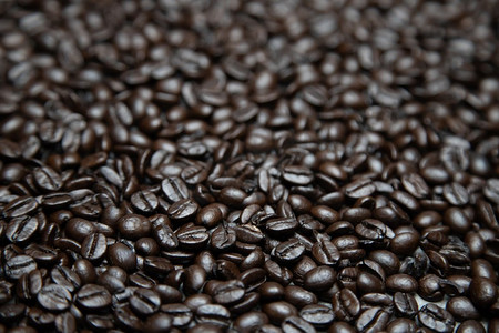 照片中微距特写烘焙咖啡豆的深色质地，可以作为背景。