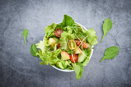 沙拉蔬菜/沙拉碗与水果和新鲜生菜西红柿黄瓜健康食品饮食概念，顶视图 