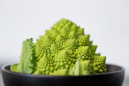 蔬菜，食物和烹饪概念—关闭罗马西兰花在陶瓷碗。关闭了罗马西兰花在碗