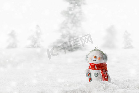 圣诞节雪人玩具在冬天森林背景在雪。雪人玩具在冬季背景