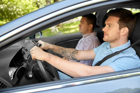 汽车驾驶课程和拼车概念—在乘客座位和年轻司机教练。汽车驾校教练和男司机