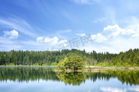 天空摄影照片_五颜六色的湖景，水中倒映着树木，中间有一个小岛