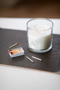 路西法摄影照片_装饰，卫生和舒适的概念-白色香味蜡烛和餐桌上托盘上的火柴。桌上托盘上的香水蜡烛和火柴