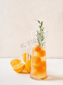 美味的柠檬水配橙汁冰块和迷迭香。清爽的夏季饮料