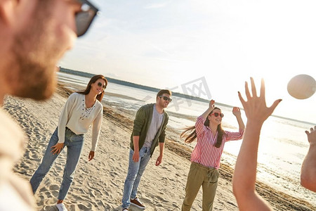 排球，休闲游戏和人的概念-快乐的朋友在夏天在海滩上玩球。夏天在海滩上打排球的朋友