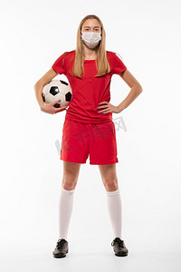 带面罩抱球的女子足球运动员