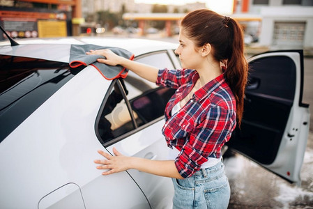女子洗完车后用抹布擦拭，抛光过程上自助洗车。女士清洁车