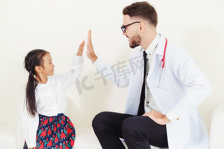 不怕吃苦摄影照片_小孩在医院办公室看医生。孩子很高兴，不怕医生。医疗和儿童保健概念。