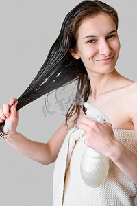 纵容摄影照片_女人用产品喷头发