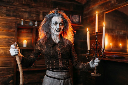 拿着烛台和拐杖的可怕女巫读着神秘的咒语,精神降神会.屏幕截图美女