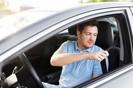 交通、车辆及安全驾驶概念——夏季男女司机系好安全带。男子或汽车驾驶员系紧安全带