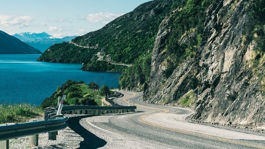 新西兰南岛昆斯敦，沿着山崖和湖泊景观蜿蜒的道路。夏季旅行和自驾游。