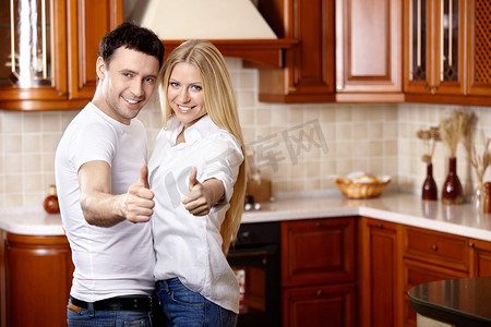 这对年轻夫妇在厨房上竖起大拇指