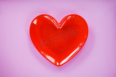 在粉红色的红心/情人节晚餐浪漫爱情概念—浪漫桌子设置装饰有红色心脏板在粉红色背景 