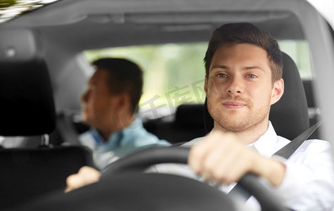 交通、人和出租车概念--男司机带着乘客开车。男出租车司机与乘客一起驾驶汽车