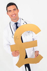 男英语英语摄影照片_快乐微笑的男医生拿着英镑的标志。医疗健康保险的成本医疗保健概念。