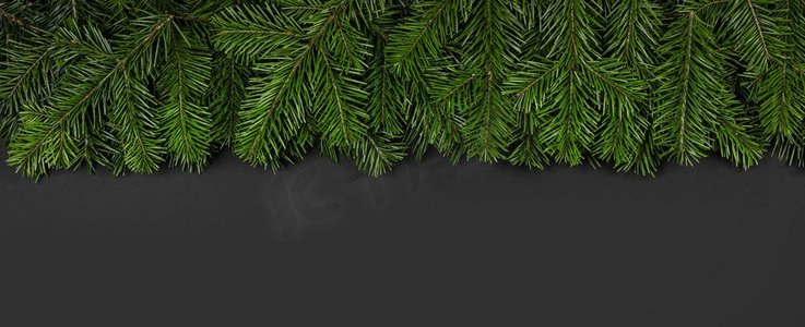 圣诞节边界安排有新鲜的冷杉枝和松果在黑色纸背景，复制空间文本。圣诞节边界冷杉树枝