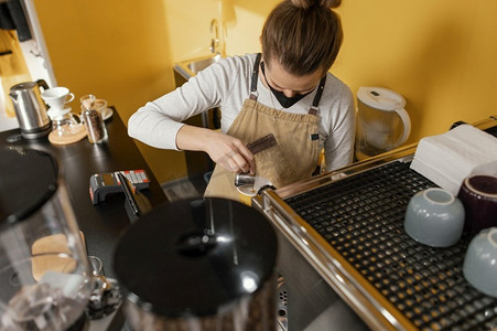 波浪状师摄影照片_女咖啡师与面具工作咖啡馆