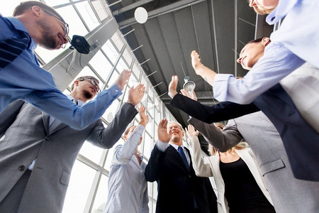 企业、成功和团队合作理念—快乐的商业团队在办公室里击掌。商务人士在办公室击掌
