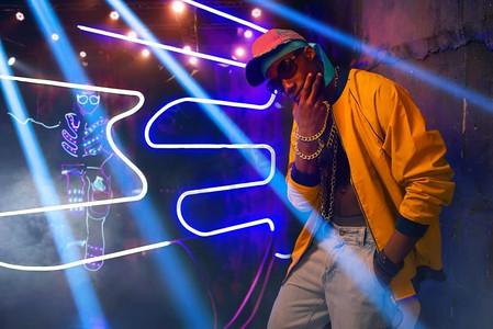 背景下地下通道霓虹灯中的黑人说唱歌手.屏幕截图人物活动