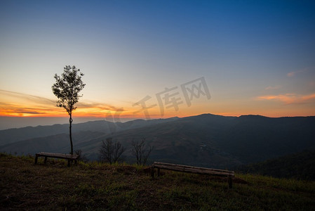 竹景观摄影照片_日落或日出在视点山山黄色和蓝色的天空与树和竹长凳