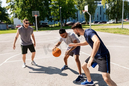 运动、休闲游戏和男性友谊的概念--一群男人或朋友在街头打篮球。一群在街头打篮球的男性朋友