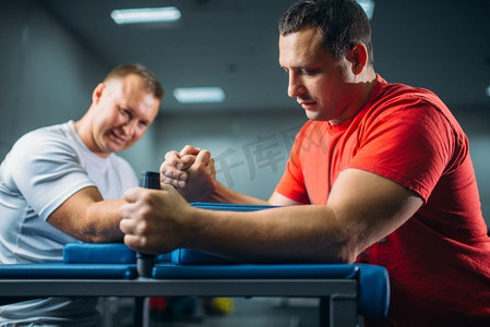 两个手臂摔跤手在他们的手在桌子上用别针，战斗在行动，摔跤比赛。摔跤挑战，力量运动