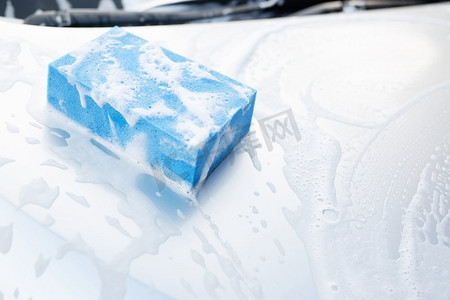 新店开业洗车摄影照片_人们手持蓝色海绵洗车。