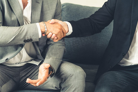 商人握手与另一个商人伙伴在现代工作场所办公室。人的企业商业交易概念。