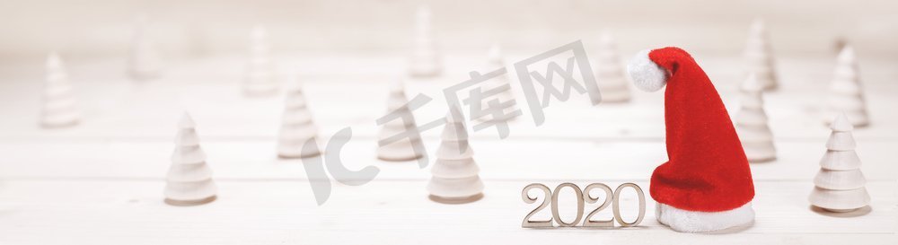 2020新年摄影照片_概念性的2020年新年背景与小木冷杉2020年数字和红色圣诞老人帽子。概念2020新年背景