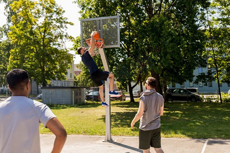 体育、休闲游戏和男性友谊概念—一群男人或朋友打街头篮球。一群男性朋友打街头篮球
