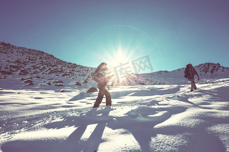 登山徒步的人摄影照片_冬山中的徒步旅行者