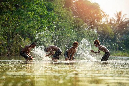 在河的亚洲儿童/男孩朋友愉快的滑稽玩耍的水在水的溪流在生活的农村的孩子农民农村人
