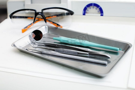 桌子上有牙科器械和防护眼镜。牙科器械