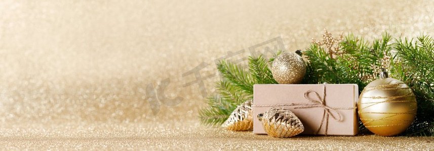 闪光框摄影照片_圣诞节玩具，装饰品，礼物盒包装在牛皮纸在金色闪光背景，复制空间。圣诞礼品盒和装饰